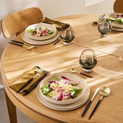 two plates of food on the table with utensils