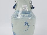 a blue and white vase sitting on a white surface