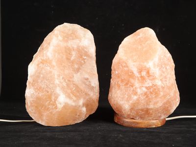 pair of himalayan salt lamps sitting on a black surface