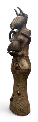 une statue représentant un dragon posée au sommet d'un vase