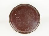 brown plate on a white surface with a small hole in the middle of it