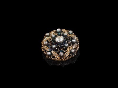 un gros plan d'une bague en or et diamants sur fond noir