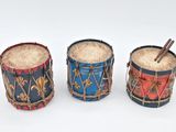three drums are lined up in a row on a white surface