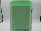 a bottle of green liquid sitting on a table