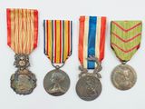 trois médailles et une médaille sur une surface blanche