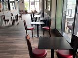 des tables et des chaises dans un restaurant donnant sur l'extérieur