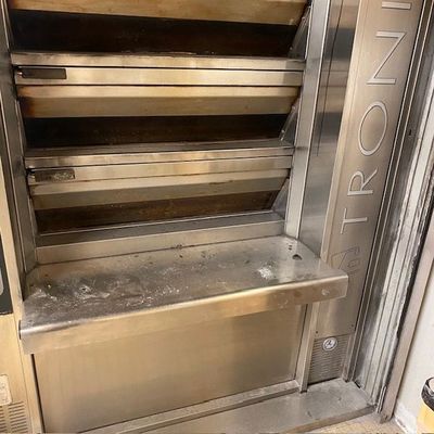 un four en métal posé dans un coin d'une pièce