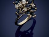 a gold ring with blue and white diamonds on a dark background