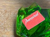 a green bottle with a red label sitting on a wooden table