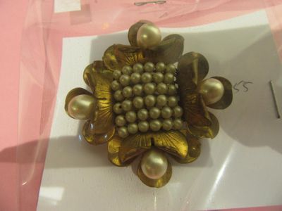 une photo d'une broche ornée de perles