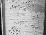 black and white photograph of a framed piece of paper with writing on it