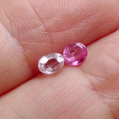 someone is holding a pair of pink sapphires in their hand