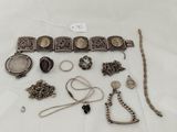 a lot of silver jewelry on a white table