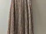 the skirt is hanging on a hanger against a wall