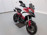 une moto rouge et blanche garée à l'intérieur d'un bâtiment