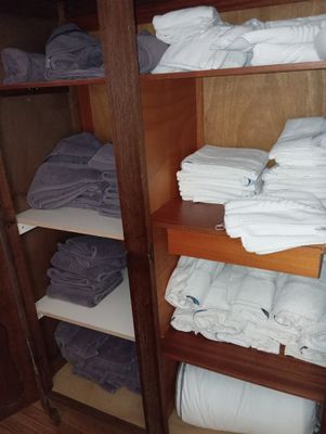 many folded towels on a shelf in a closet
