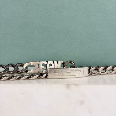 un bracelet en argent gravé d'un prénom, posé sur une table