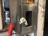a red chair sitting in front of a metal oven