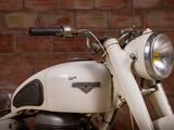 a close up of a motorcycle parked in front of a brick wall