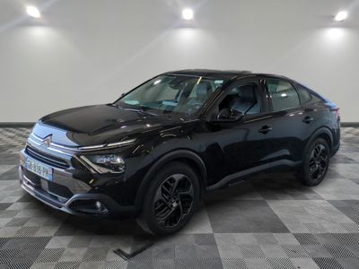 Un SUV noir est garé dans une grande pièce au sol carrelé.