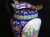 un vase bleu orné d'un oiseau sur fond noir