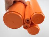 a person holding two orange plastic cylinders in their hand