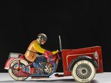 une moto jouet rouge avec un homme dessus