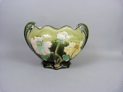 un vase sur lequel sont peintes des fleurs sur fond blanc