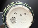 a black and white vase with a green stripe on it