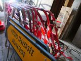 a yellow street sign with red ribbons on it