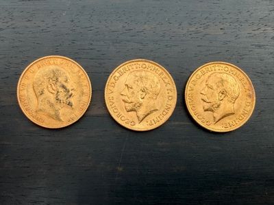 trois pièces d'or posées les unes à côté des autres sur une table