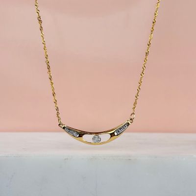 un collier plaqué or orné d'un diamant blanc sur fond rose