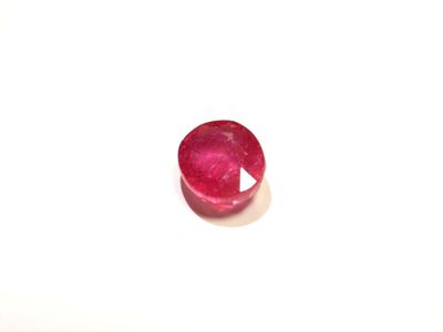 un gros plan d'une pierre rouge sur une surface blanche