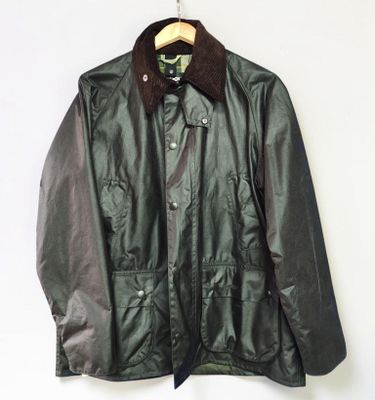 leather jacket with fur collar on hanger against white wall