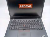 the laptop is open on a white surface with a red lenovo logo on the screen
