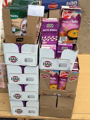 Plusieurs cartons de nourriture sont empilés sur une palette dans un magasin