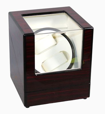 une photo d'un remontoir de montre en bois muni d'un couvercle en verre