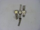 three watches are sitting on a white surface next to each other