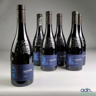 six bottles of wine are lined up on a white surface