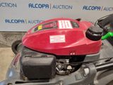a red lawn mower that is sitting on the ground