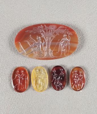 un ensemble de quatre boutons en verre sculpté posés sur une surface blanche