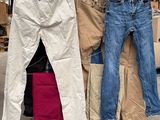 Plusieurs paires de jeans sont empilées les unes sur les autres dans un entrepôt