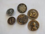 six antique brass buttons on a white table cloth