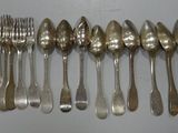a lot of silver spoons and forks on the table