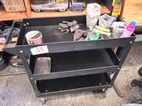 a black work cart with tools on it in a garage