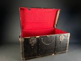 a black trunk with a red lining inside of it
