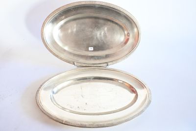 une petite boîte en argent avec un couvercle en argent, posée sur une surface blanche
