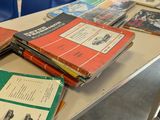 several books are stacked on a table in a classroom