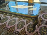 a glass coffee table with a glass top on a rug