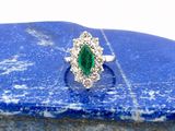 une bague ovale sertie d'émeraudes et de diamants, montée sur une pierre bleue